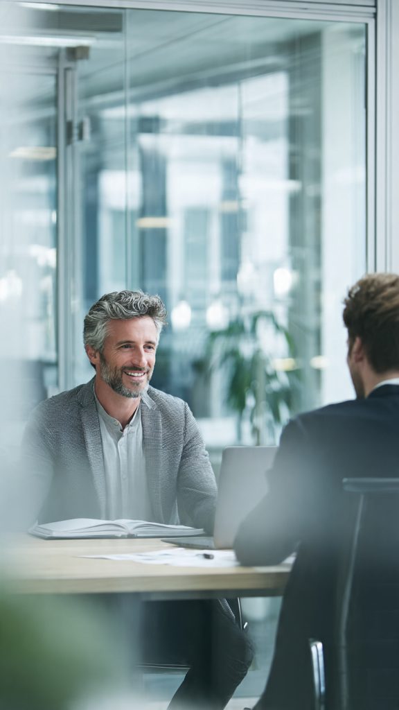 Ask for a Role Change
“A modern office setting showing a professional employee having a calm discussion with a manager across a desk. The employee looks confident and prepared, holding a notebook or document. The manager is listening attentively. The environment is bright, minimal, and corporate with glass walls, laptops, and subtle plants. The mood is positive, focused on career growth and internal role transition. Soft natural lighting, realistic style, high detail, 16:9 composition, professional business photography.”