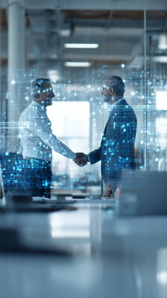 Offer Real Value in an AI World
A professional recruitment consultant shakes hands with a job candidate across a desk in a modern office. A glowing AI digital interface with connected network icons appears in the background, symbolizing the integration of artificial intelligence and human expertise in recruitment. The scene represents how recruitment agencies create value through relationships, trust, and strategic hiring in an AI-driven world.